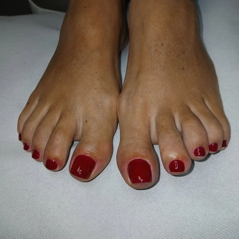 Stopy po pedicure, czerwony lakier